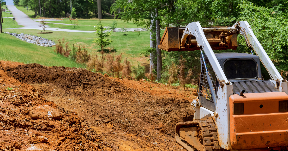 Skid steer working a dirt lot
